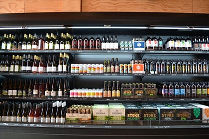 beer and wine stacked on shelves on black multideck
